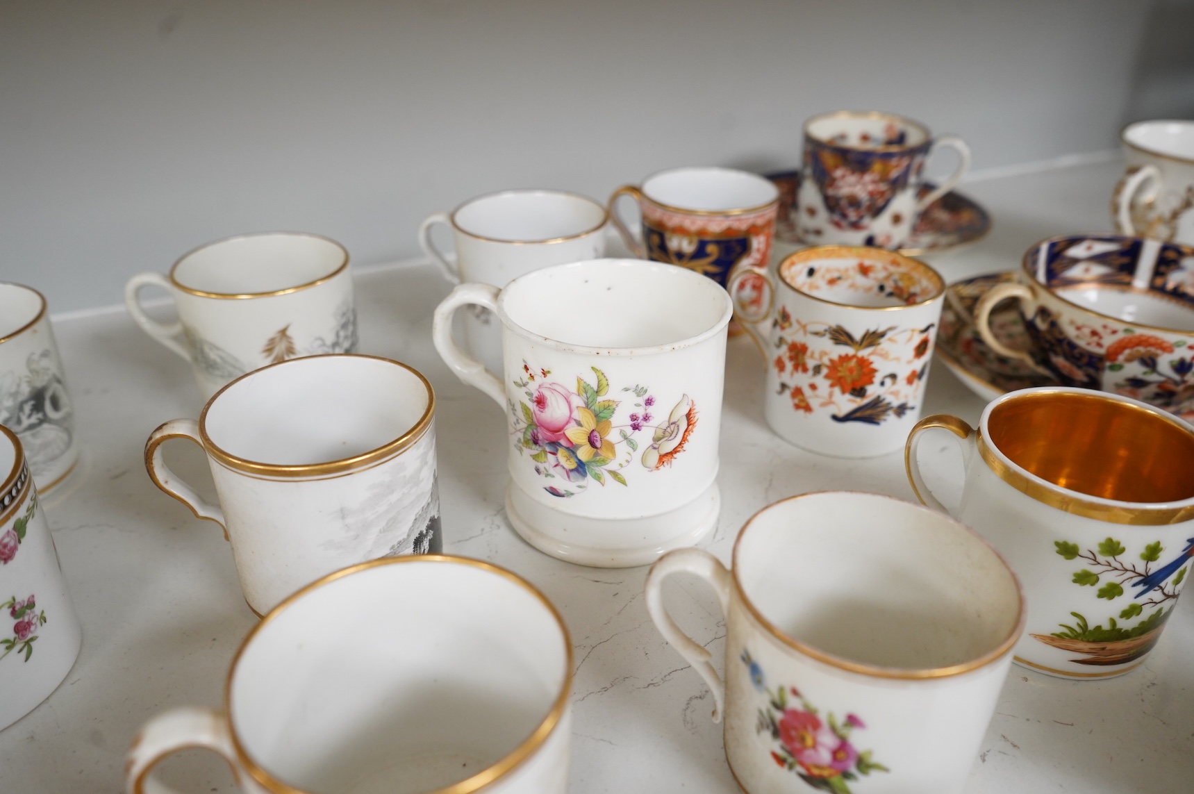 A collection of late 18th/19th century English and French porcelain coffee cans, tea cups and vases, some in Imari pattern